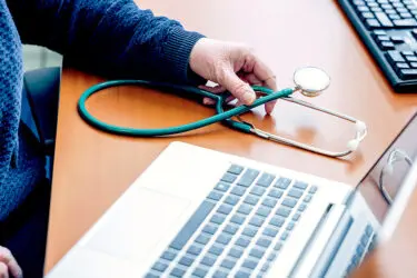 Foto van laptop met stethoscoop ernaast