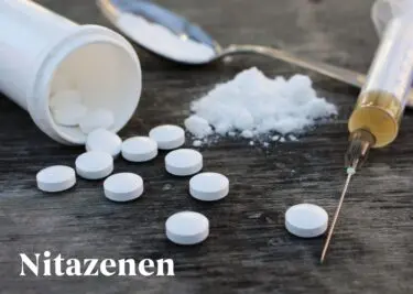 Foto met drugs in poeder-, pillen- en spuitvorm op een houten tafel
