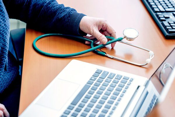 Foto van laptop met stethoscoop ernaast