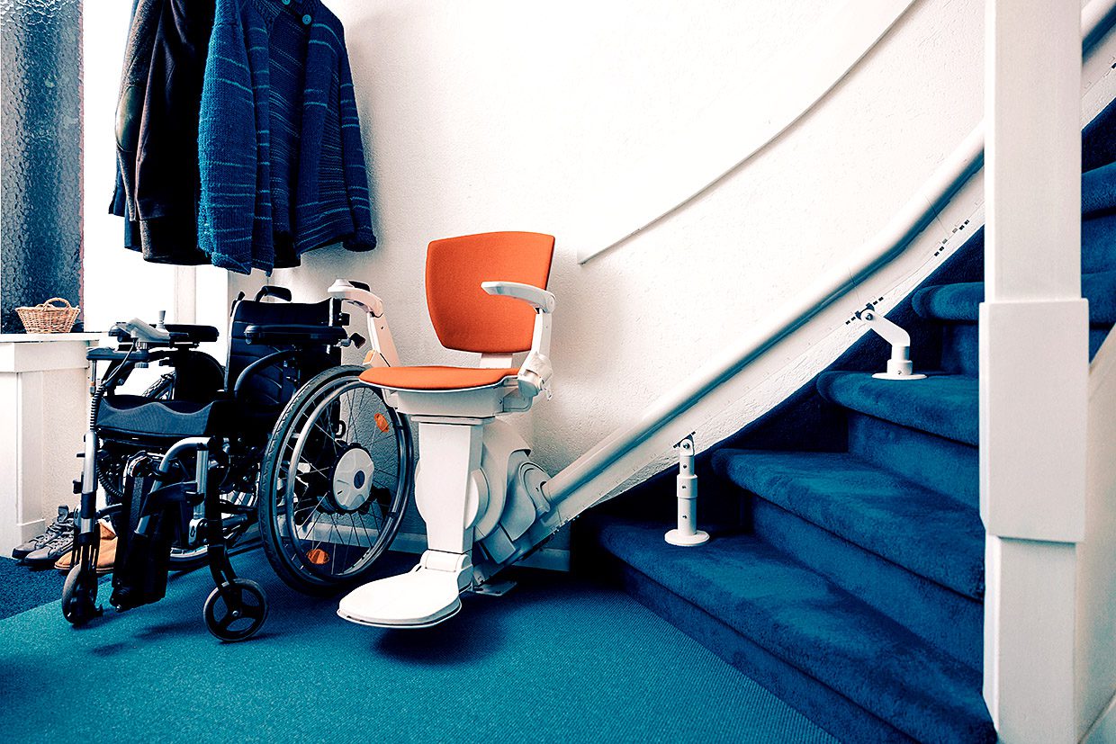 Foto van een trap met daaronder een traplift en rolstoel