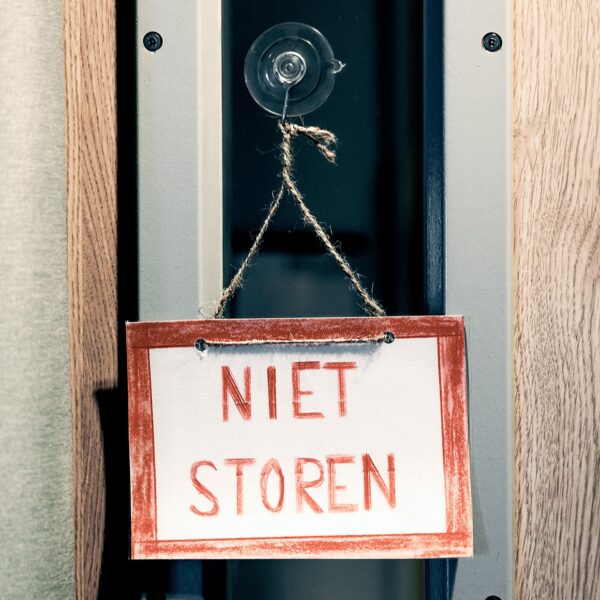 Foto van een deur met aan de deurknop hangend een bordje 'niet storen'